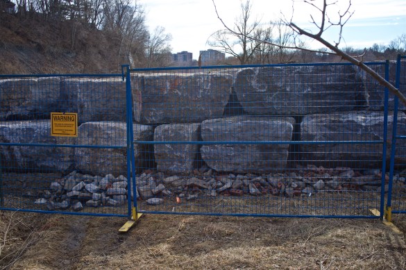 Blocks for the retaining wall are waiting to be installed. The fence is about 6' high.