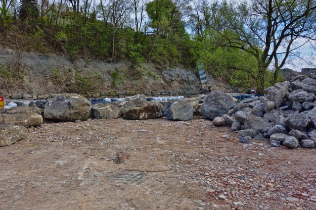 Old retaining wall blocks are stacked along the opposite shore.